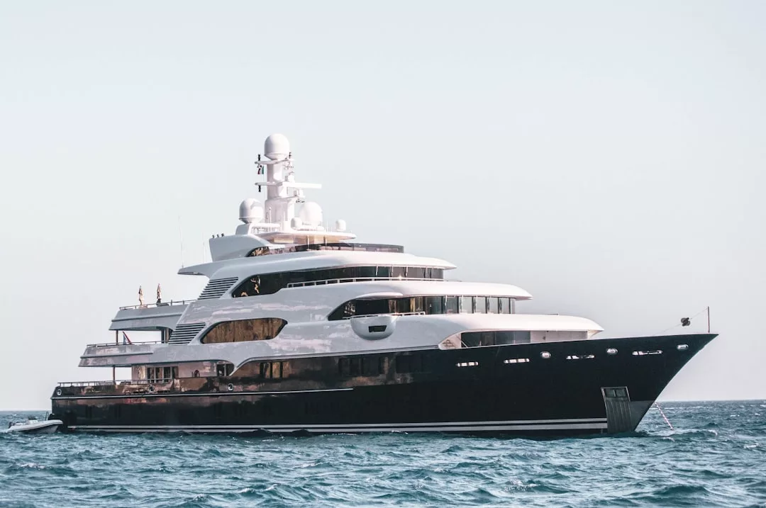 Große Luxusyacht mit mehreren Decks und modernem Design, die in der Nähe von Mallorca auf ruhigem Wasser unter klarem Himmel schwimmt.