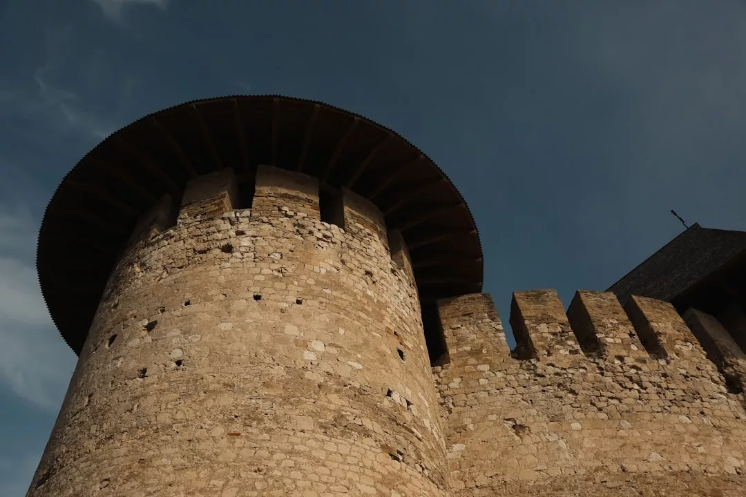 Steinerne Festung mit rundem Turm und Zinnen, von unten gesehen vor dem klaren blauen Himmel Mallorcas.