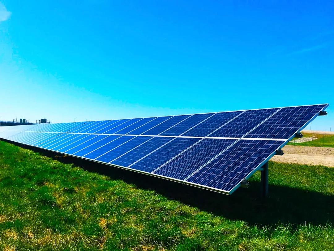 Eine Reihe von Solarmodulen ist auf einer Wiese unter dem klaren blauen Himmel Mallorcas installiert.