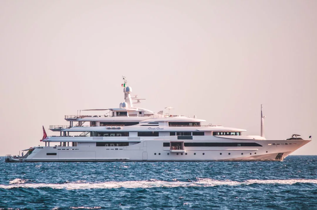 Eine große weiße Luxusyacht, die in den ruhigen blauen Gewässern vor Mallorca unter einem klaren Himmel kreuzt, mit mehreren Decks und modernen Designmerkmalen.